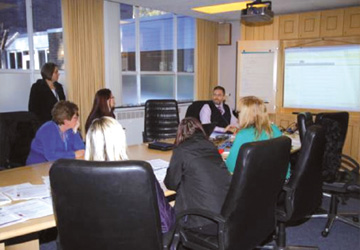 business people at a desk discussing the what is displayed on a screen