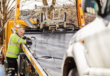 a man in high-vis leaning on a recovery truck