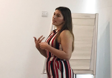 a woman standing giving a presentation