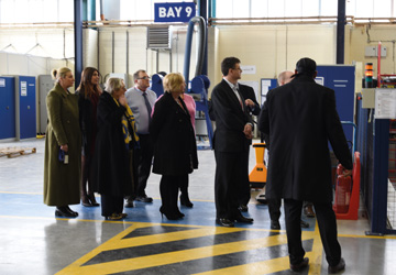 people in business dress standing on the factory floor