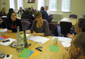 a group of people sitting at a table having a discussion