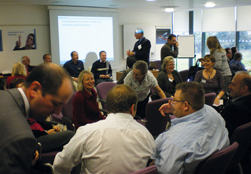 a group of people in business dress , all sitting on chairs and talking