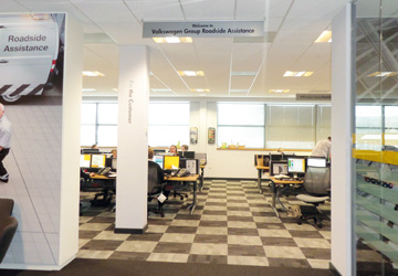 an office with yellow desks, white walls and black and white squares on the floor 