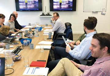 people in business dress sitting at a large desk