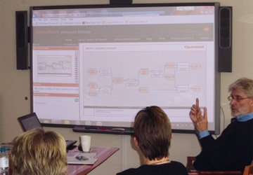 a man pointing at a process map projected on screen