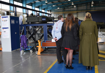 people in business dress on the factory floor