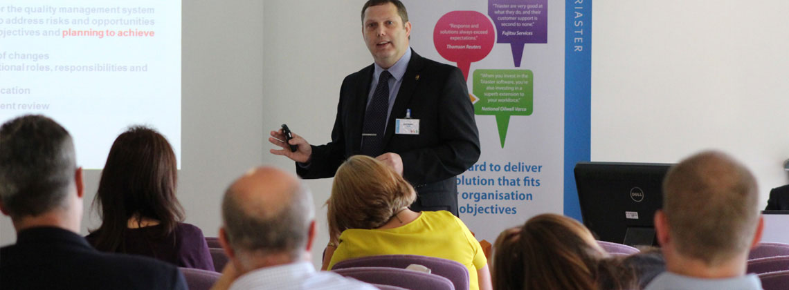 a man in a suit presenting to an audience 