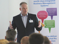 man in a suit presenting to an audience